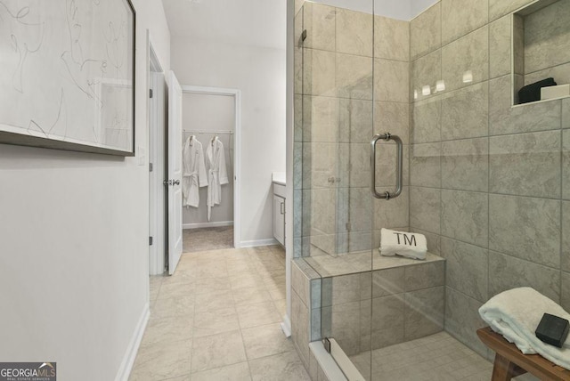 bathroom featuring a stall shower, tile patterned floors, baseboards, and vanity