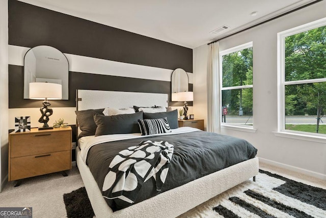 bedroom with light colored carpet, visible vents, and baseboards