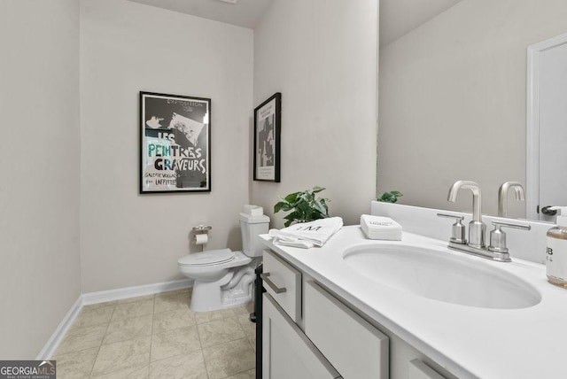 bathroom featuring tile patterned flooring, baseboards, vanity, and toilet