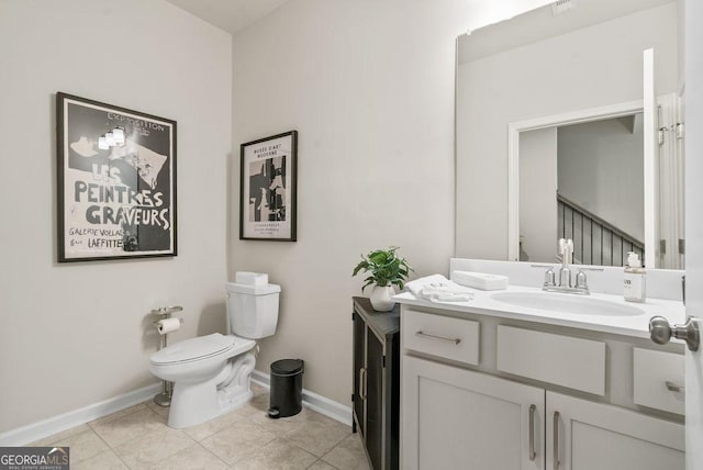 bathroom featuring toilet, tile patterned flooring, baseboards, and vanity