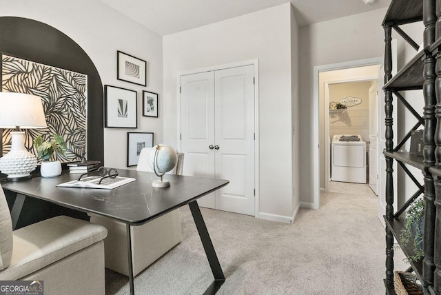 home office with light carpet, washer / clothes dryer, and baseboards