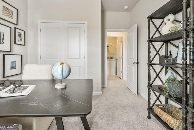 home office with baseboards, washer / clothes dryer, and light colored carpet