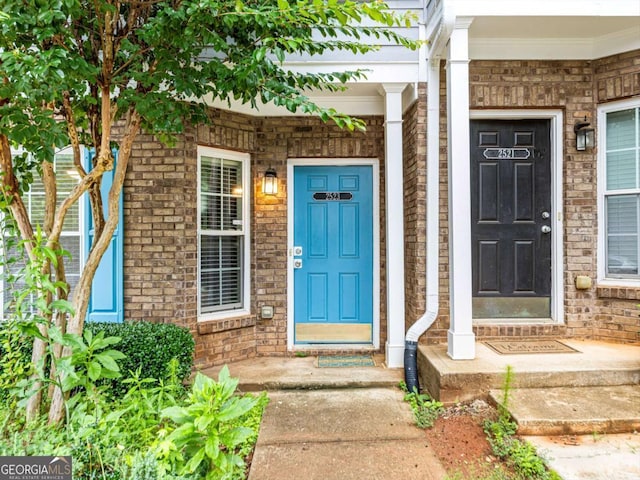 view of exterior entry with brick siding