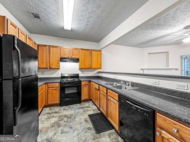 kitchen featuring visible vents, brown cabinetry, dark countertops, black appliances, and a sink