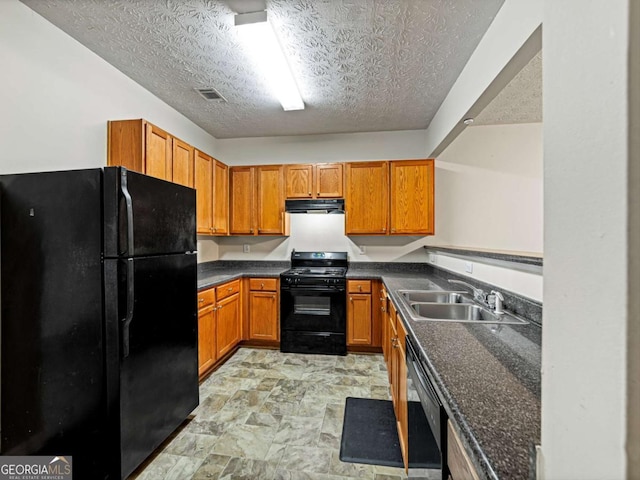 kitchen with visible vents, brown cabinetry, under cabinet range hood, black appliances, and a sink