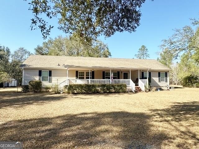 ranch-style house featuring a front yard and covered porch