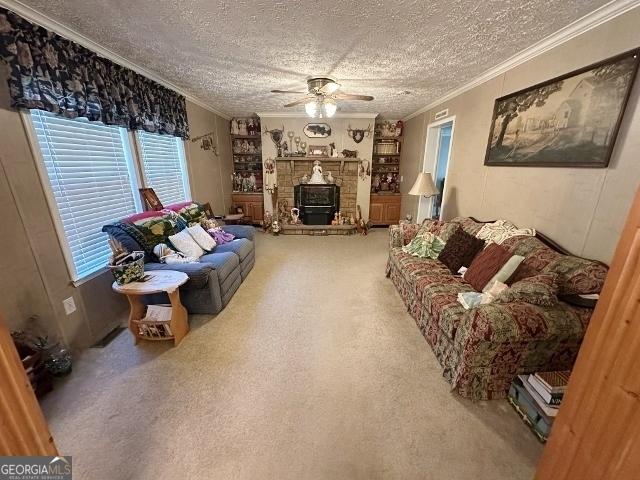 living area with carpet floors, ornamental molding, and a textured ceiling