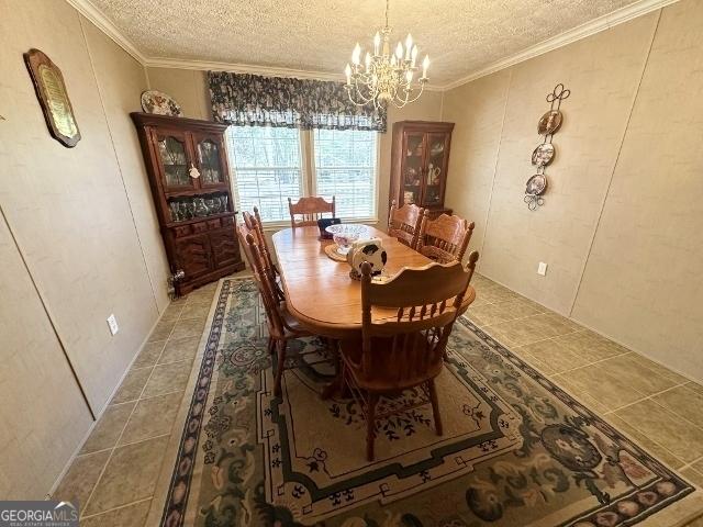 dining room with a notable chandelier, crown molding, a textured ceiling, and light tile patterned floors