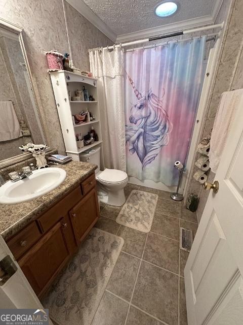 bathroom featuring toilet, ornamental molding, a textured ceiling, vanity, and tile patterned flooring