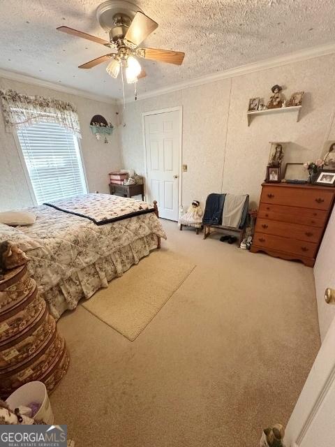 carpeted bedroom with ceiling fan, a textured ceiling, and crown molding