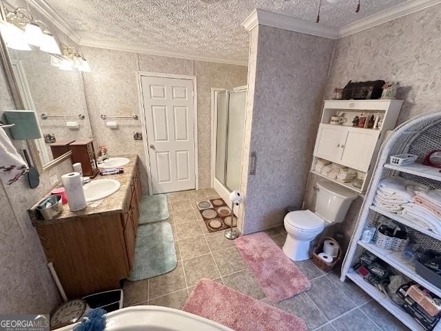 full bathroom featuring ornamental molding, a stall shower, and a textured ceiling