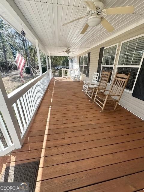 wooden deck featuring a porch and a ceiling fan