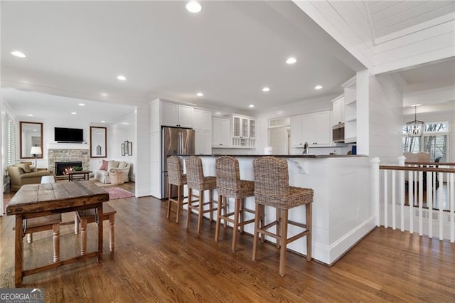 kitchen featuring open floor plan, stainless steel appliances, a peninsula, and white cabinets