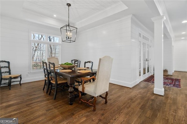 dining room featuring recessed lighting, dark wood-style flooring, a raised ceiling, decorative columns, and crown molding