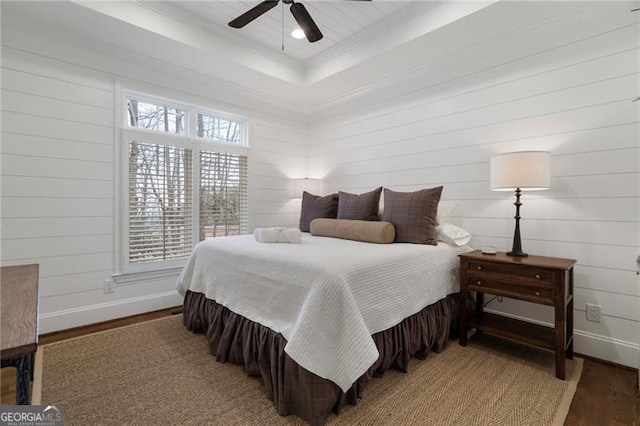 bedroom featuring crown molding, ceiling fan, baseboards, and wood finished floors