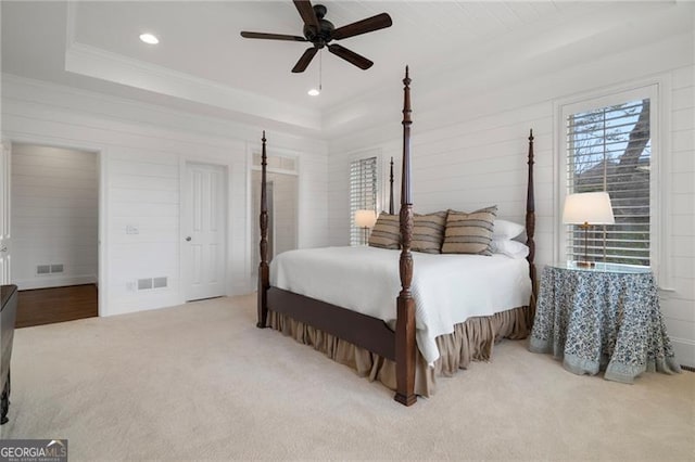 bedroom with recessed lighting, light carpet, visible vents, ornamental molding, and a raised ceiling