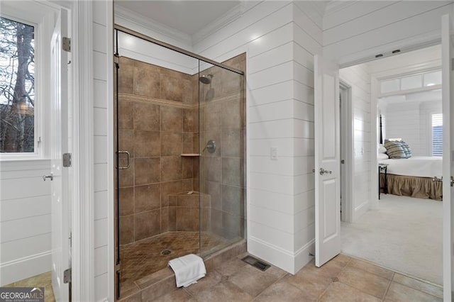 bathroom with ornamental molding, a stall shower, connected bathroom, and tile patterned floors