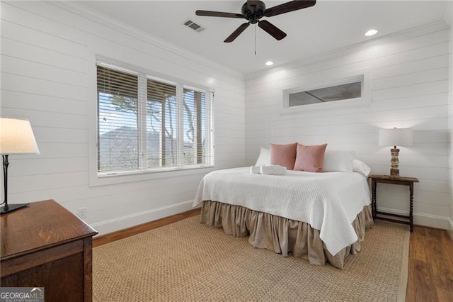 bedroom with recessed lighting, wood finished floors, visible vents, baseboards, and ornamental molding