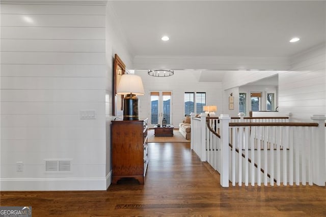 hallway featuring visible vents, dark wood-style flooring, crown molding, an upstairs landing, and recessed lighting