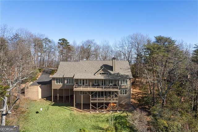 rear view of property featuring a deck and a lawn