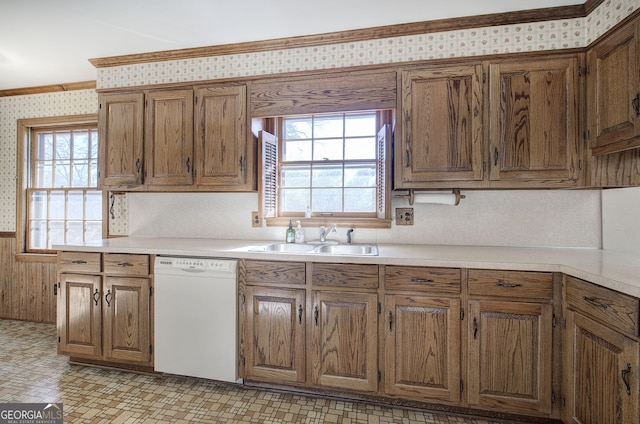 kitchen featuring wallpapered walls, plenty of natural light, dishwasher, light countertops, and a sink