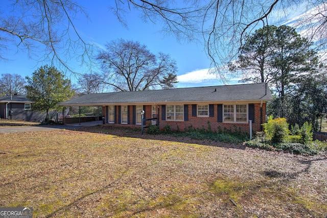 ranch-style home with a carport, brick siding, and driveway