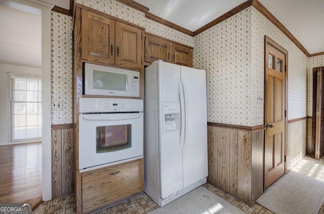 kitchen with ornamental molding, white appliances, a wainscoted wall, and wallpapered walls