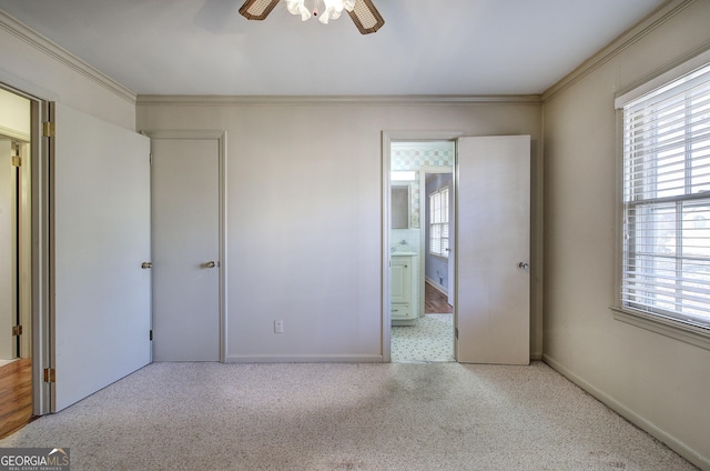 unfurnished bedroom featuring carpet, multiple windows, and crown molding