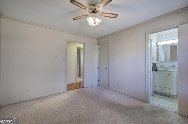 unfurnished bedroom featuring ornamental molding, carpet flooring, ensuite bath, and baseboards