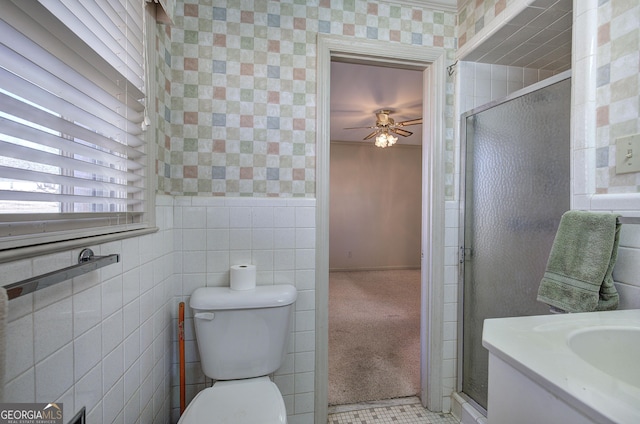 full bath with toilet, a stall shower, ceiling fan, and tile walls