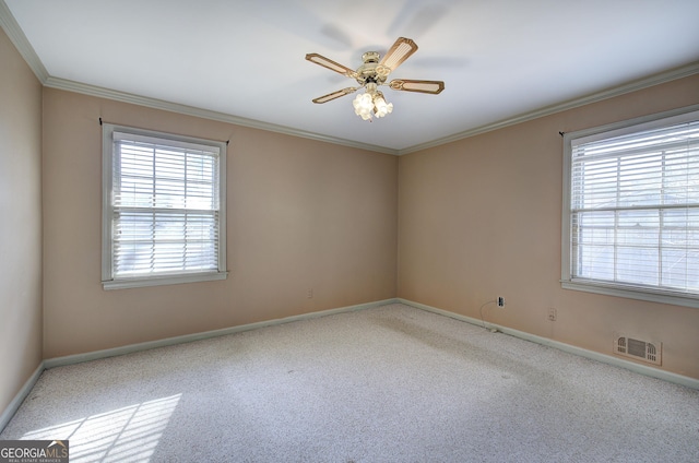 empty room with a ceiling fan, visible vents, a wealth of natural light, and ornamental molding