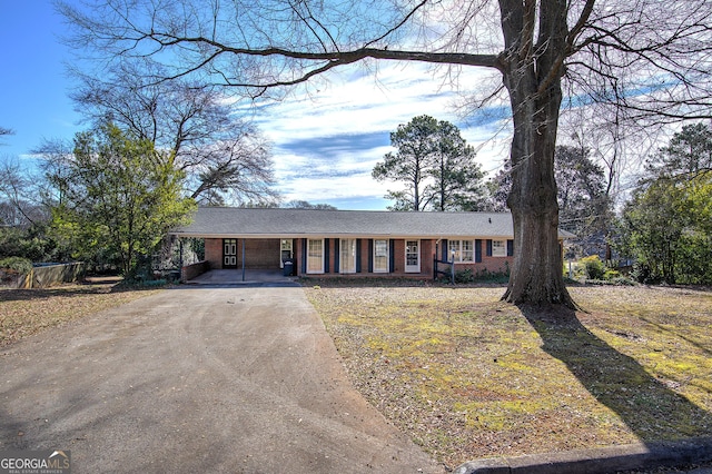 ranch-style home with driveway and brick siding