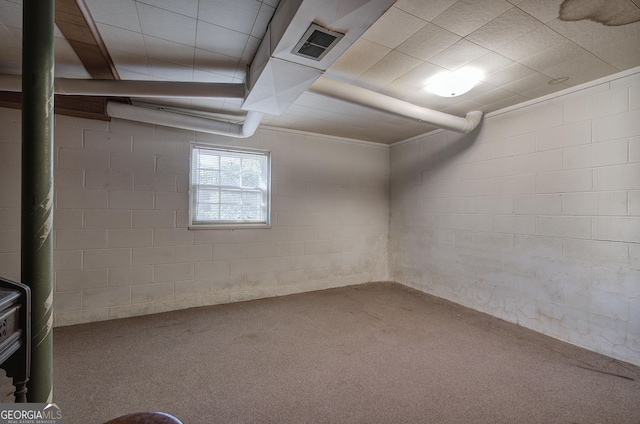 below grade area with carpet, visible vents, and concrete block wall