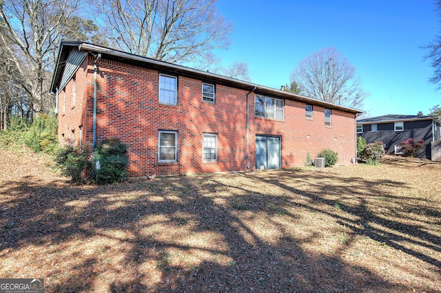 rear view of property featuring brick siding and central air condition unit