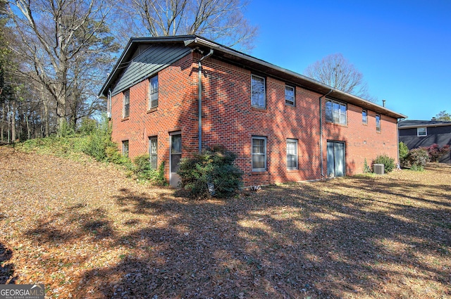 rear view of house with brick siding and cooling unit