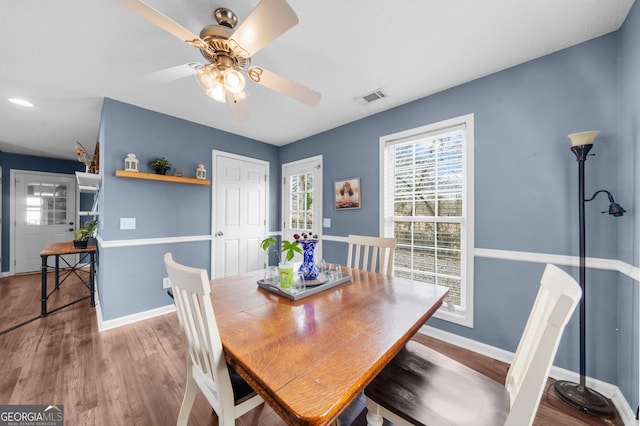 dining space with ceiling fan, wood finished floors, visible vents, and baseboards