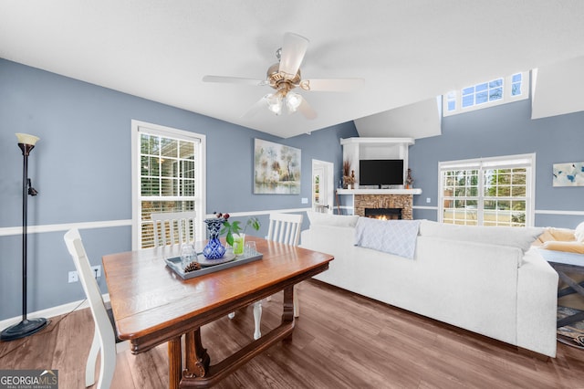 dining space with a fireplace, wood finished floors, and a healthy amount of sunlight