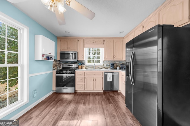 kitchen featuring stainless steel appliances, light countertops, backsplash, dark wood-type flooring, and baseboards