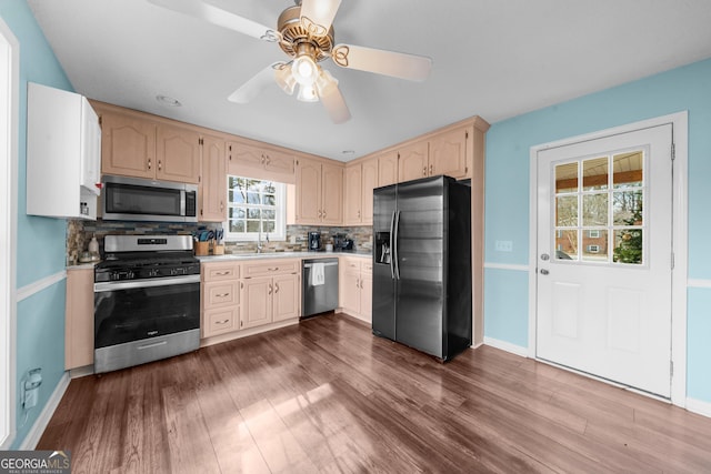 kitchen featuring stainless steel appliances, tasteful backsplash, dark wood finished floors, and light countertops