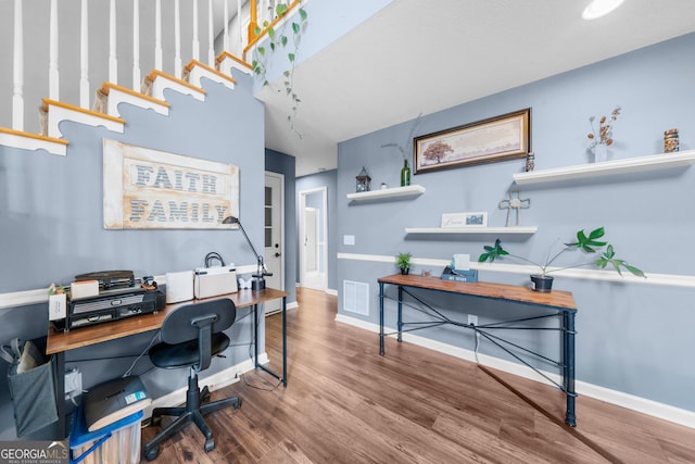 office space featuring wood finished floors, visible vents, and baseboards