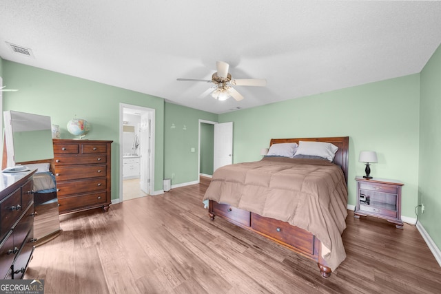 bedroom with visible vents, baseboards, and wood finished floors