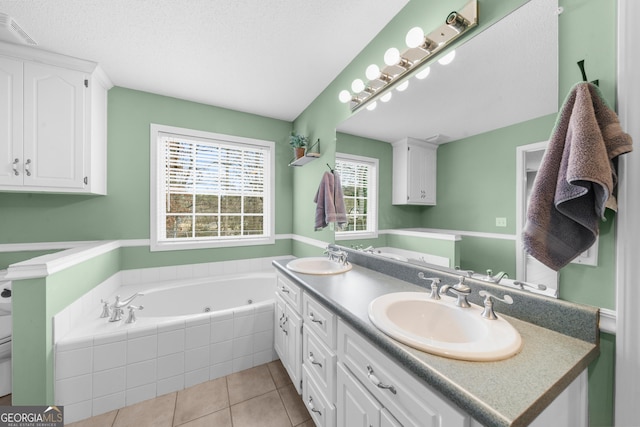 full bathroom featuring visible vents, a sink, a jetted tub, and tile patterned floors