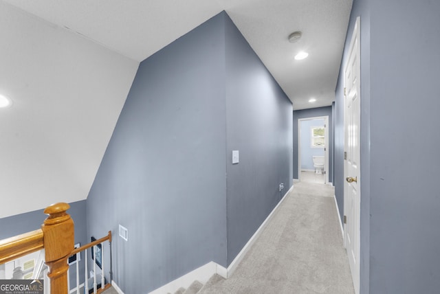 corridor featuring recessed lighting, baseboards, carpet flooring, and an upstairs landing