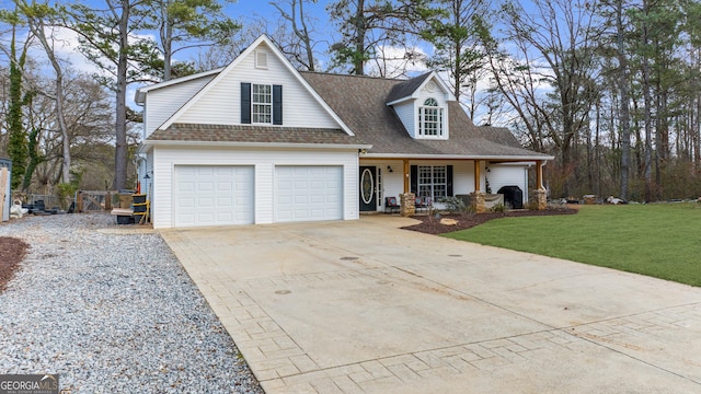 view of front of home with a garage, concrete driveway, roof with shingles, covered porch, and a front yard