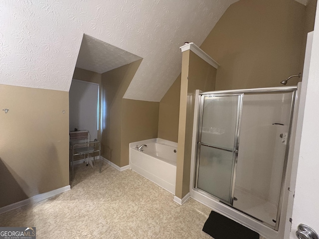 bathroom featuring lofted ceiling, a stall shower, a textured ceiling, baseboards, and a bath