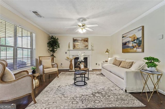 living room with ornamental molding, visible vents, and dark wood-style floors