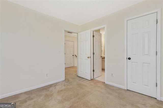 unfurnished bedroom featuring light colored carpet and baseboards