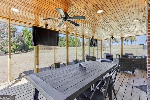 sunroom / solarium featuring wood ceiling, a ceiling fan, and a wealth of natural light