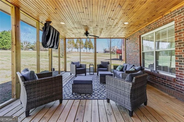 sunroom / solarium with a ceiling fan and wood ceiling