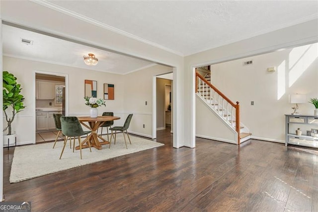 dining room with dark wood-style flooring, visible vents, crown molding, and stairway